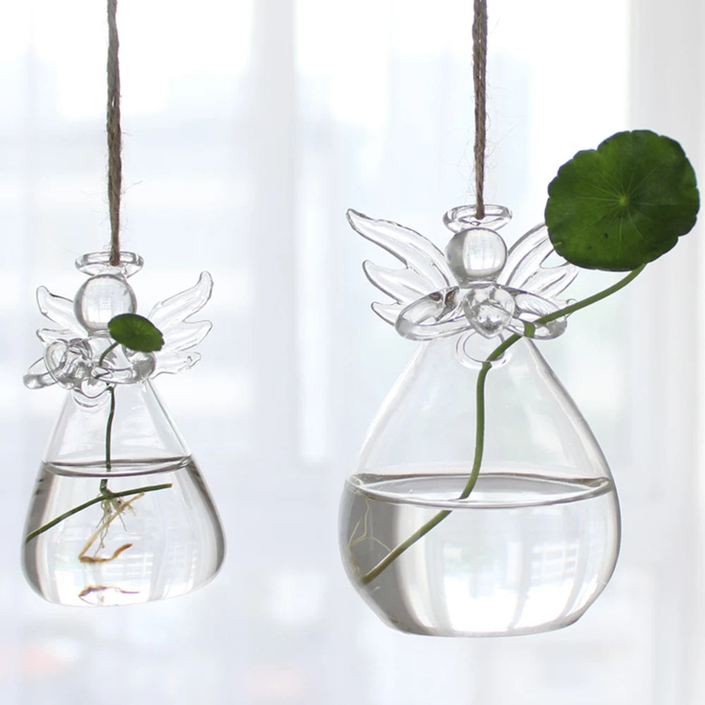 Transparent glass hanging vase in angel-inspired sculptural form with fresh flower