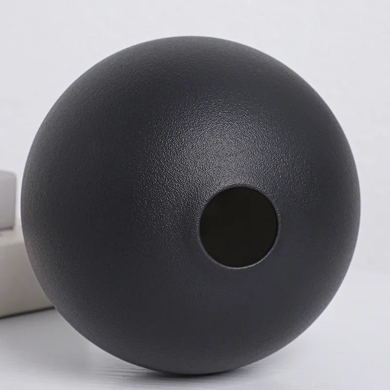 Large black ball ceramic vase as floor accent in modern living room