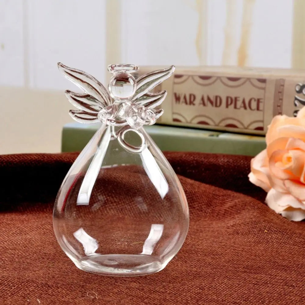 Small glass angel vase hanging on white wall with fresh flower stem