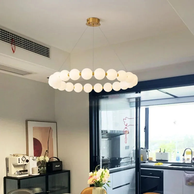 Bead strand chandelier in warm 3000K light on a chrome iron ring