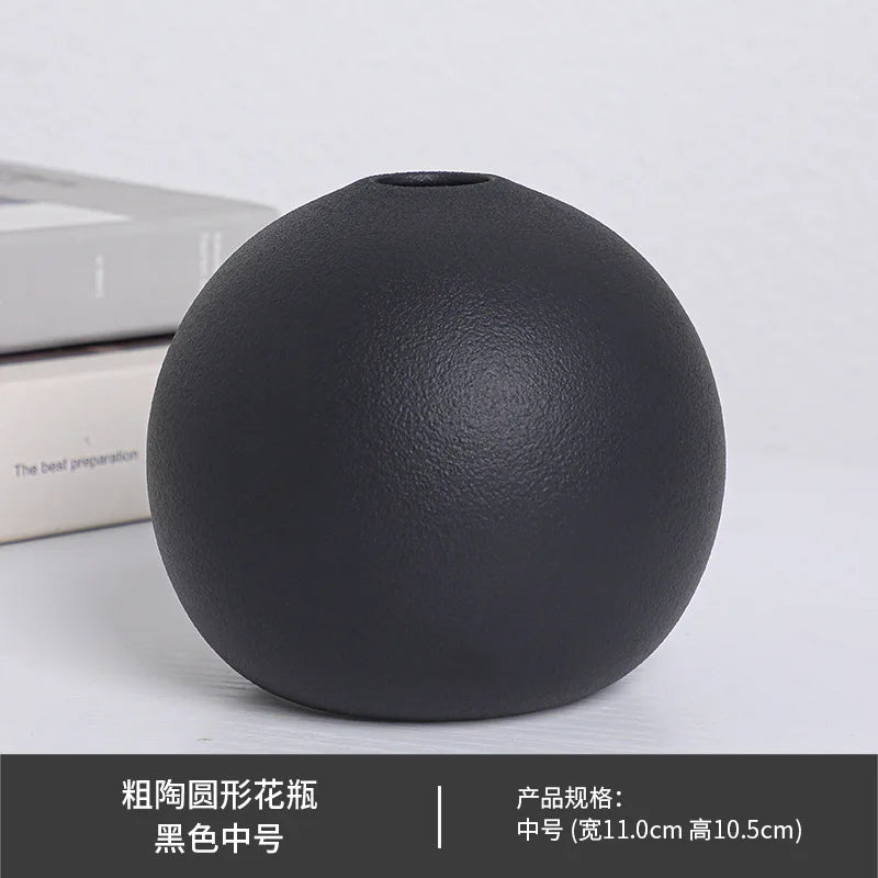 Three black ball ceramic vases in different sizes on staircase landing