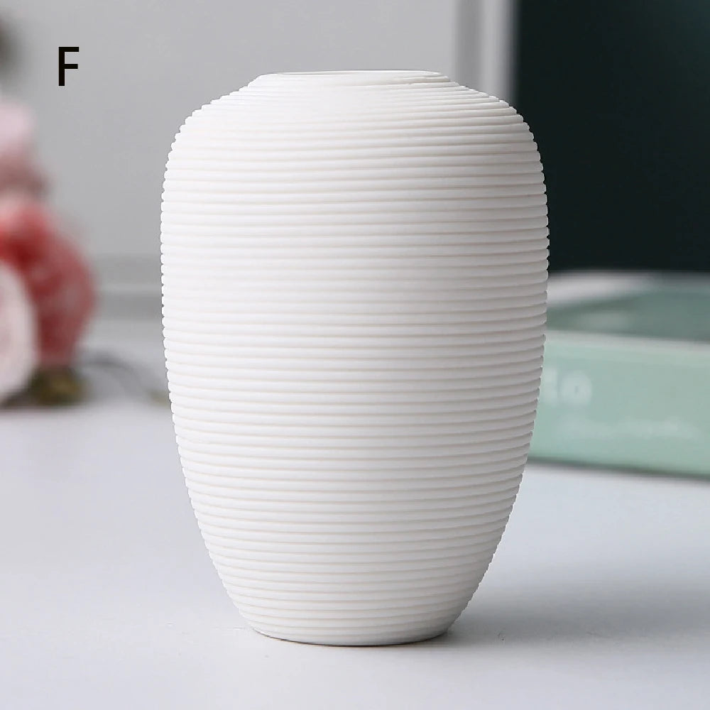 Small black ceramic vase C holding single white tulip as striking contrast accent
