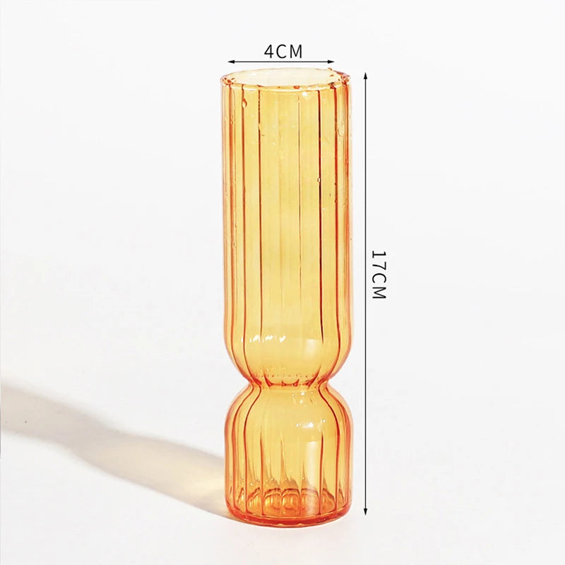 Transparent glass globe vase with trailing water plant for desktop botanical display