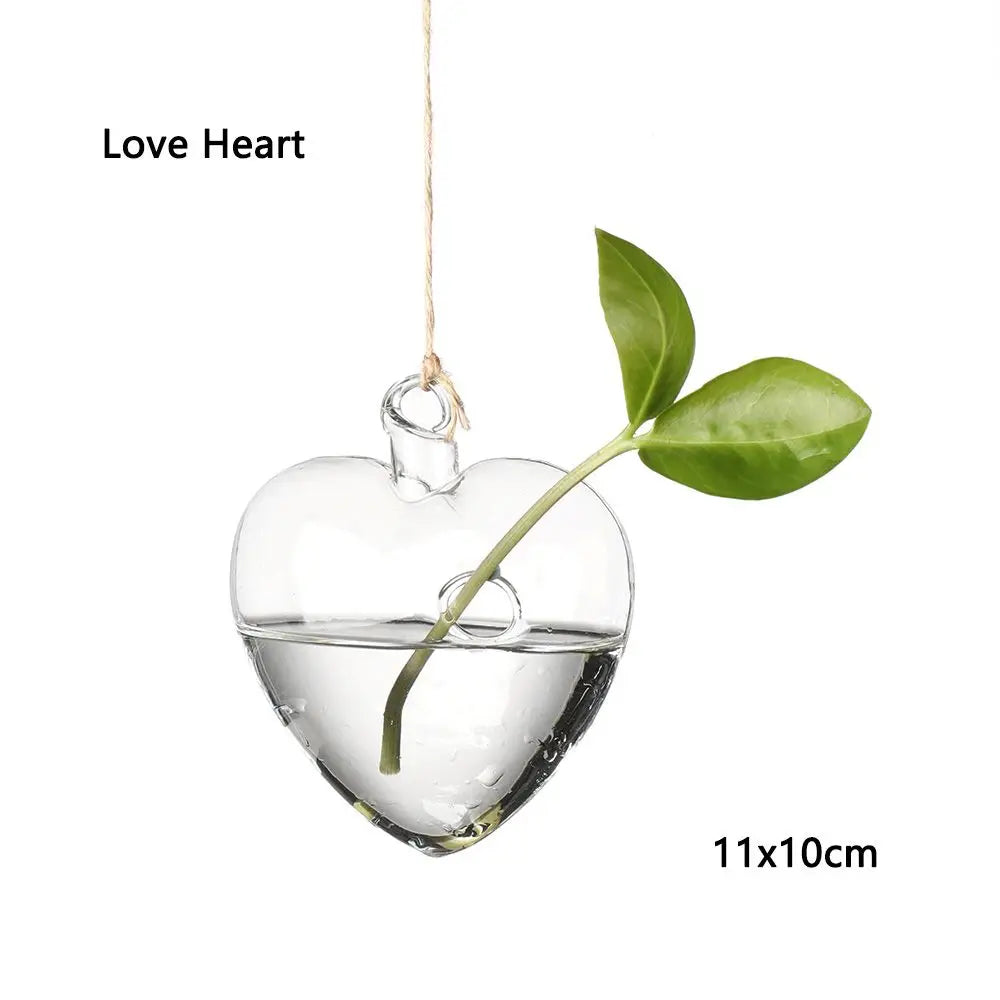 Bell hanging glass hydroponic vase with fern cutting in a bright bathroom display