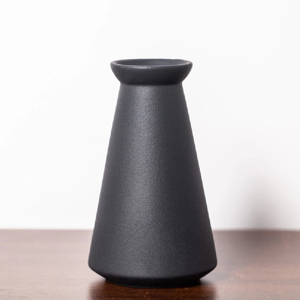 Frosted ceramic bud vase style C on a Japandi-inspired desk with pebbles and book