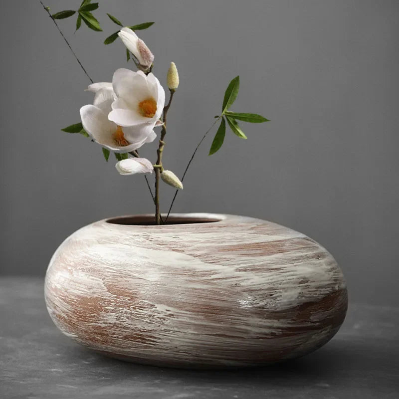 Style K abstract terracotta vase holding dried pampas grass on shelf