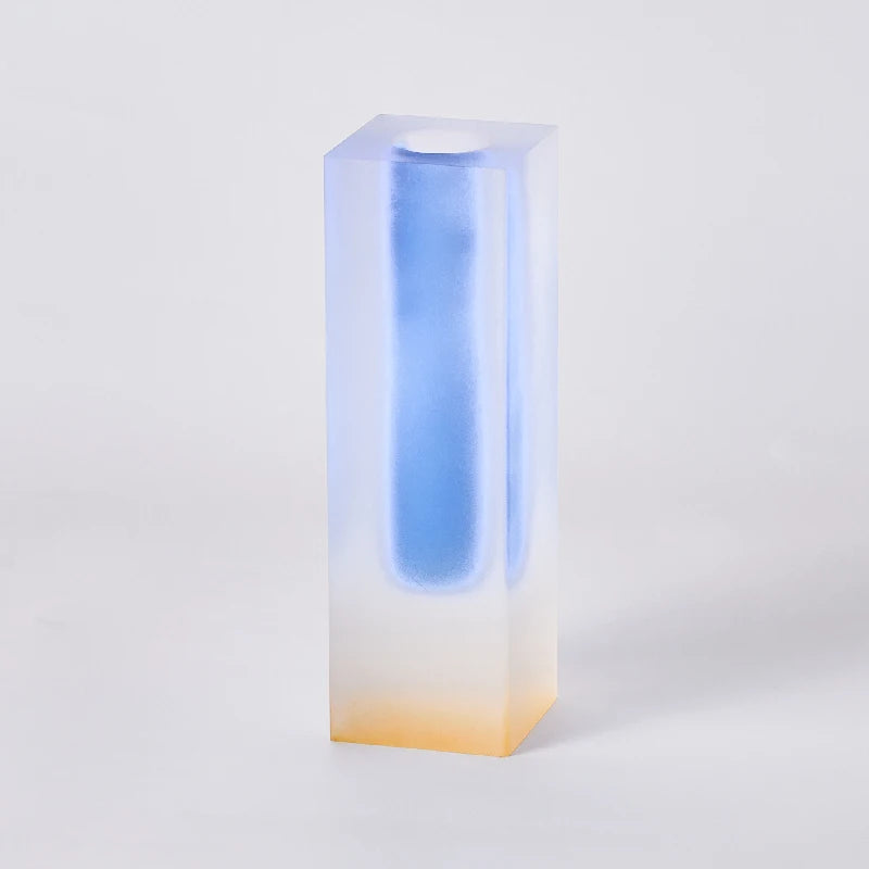 Short frosted blue acrylic pillar bud vase with small wildflower arrangement inside