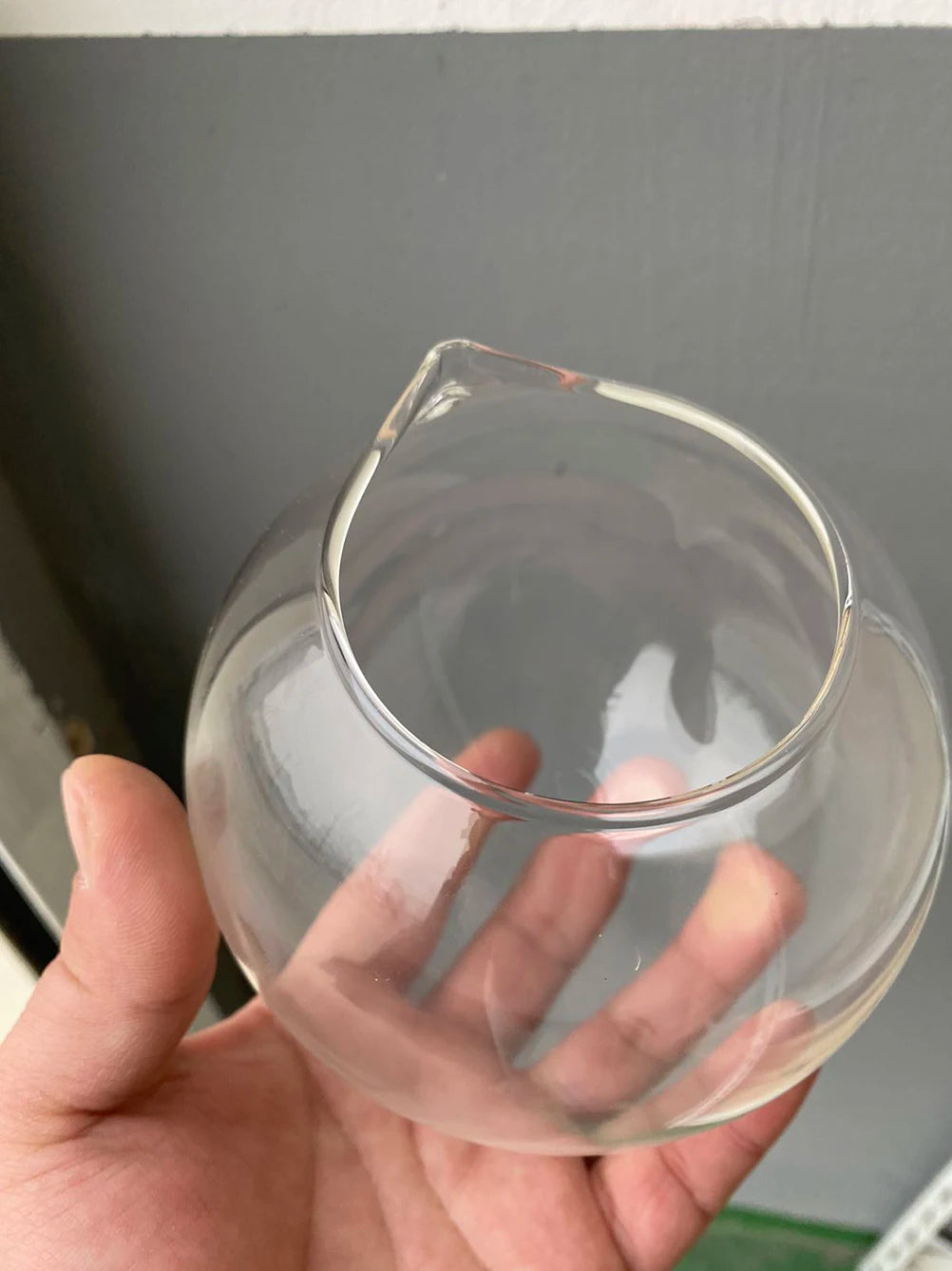 Two sizes of glass ball hanging vases shown together for scale comparison
