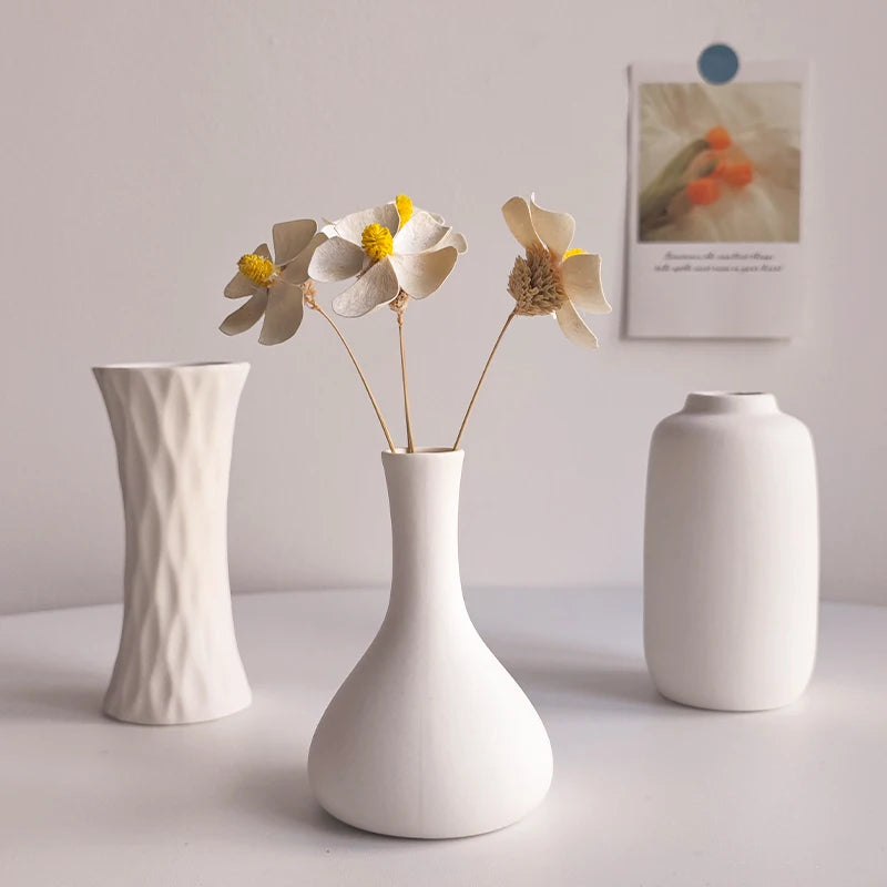 White ceramic vase C5 in small globe shape on minimalist Scandi shelf display