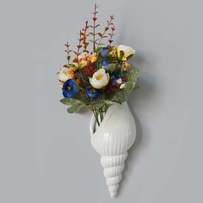 Tip-side ceramic conch vase hung on neutral wall as sculptural accent