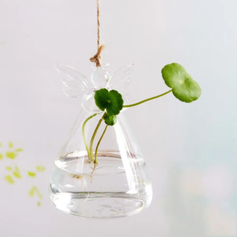 Glass angel vase displayed on desk holding single dried stem upright