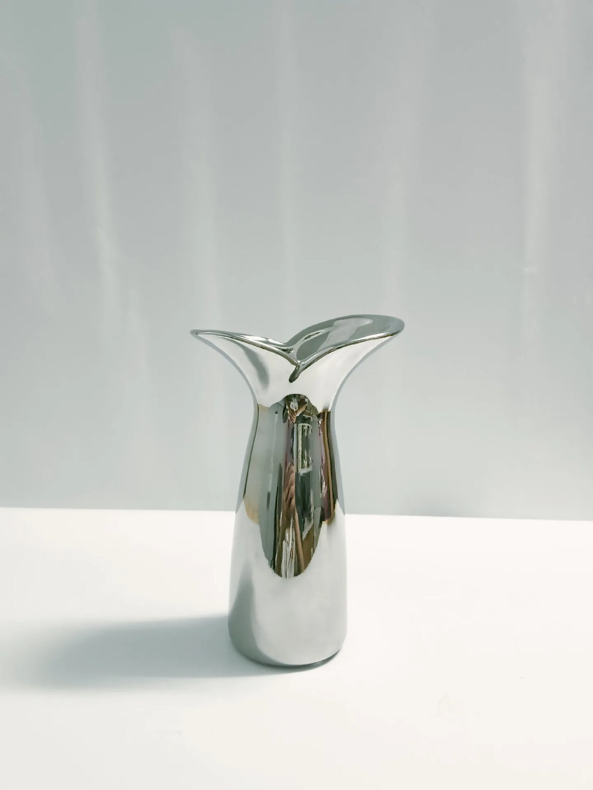 Large wabi-sabi metallic vase styled with dried pampas grass in contemporary living room