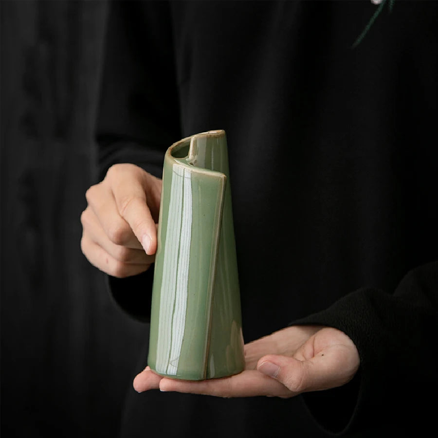 Small ceramic vase with pampas grass stem on cottagecore styled surface