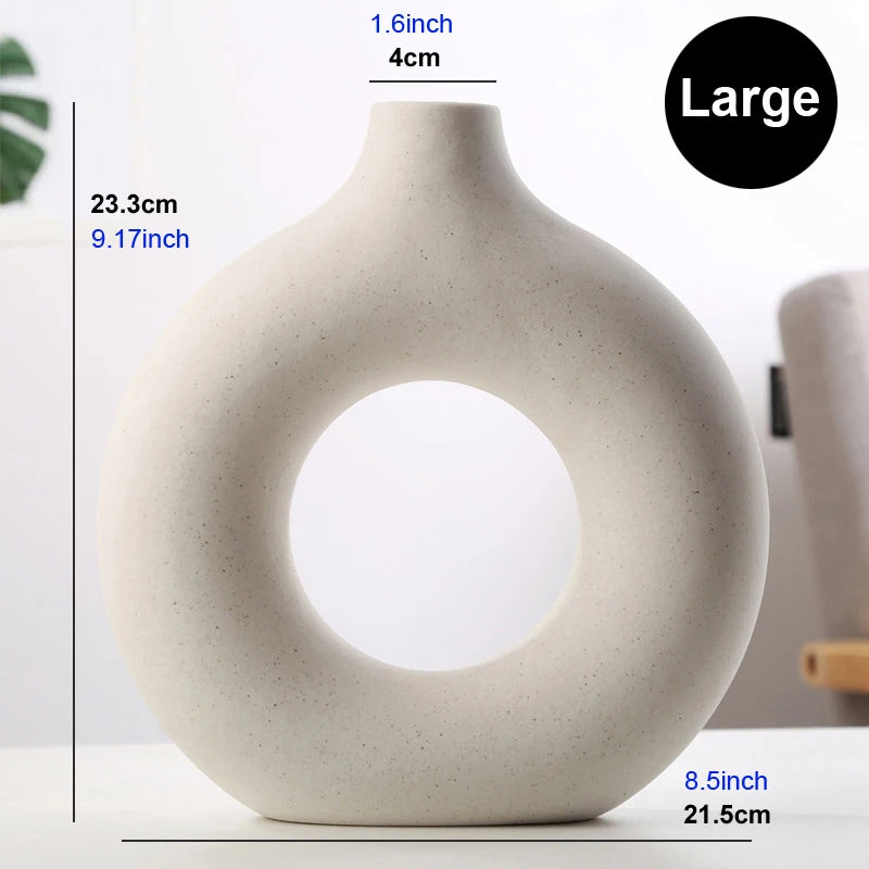 Large Nordic donut ceramic vase with dried grass stems in a living room interior