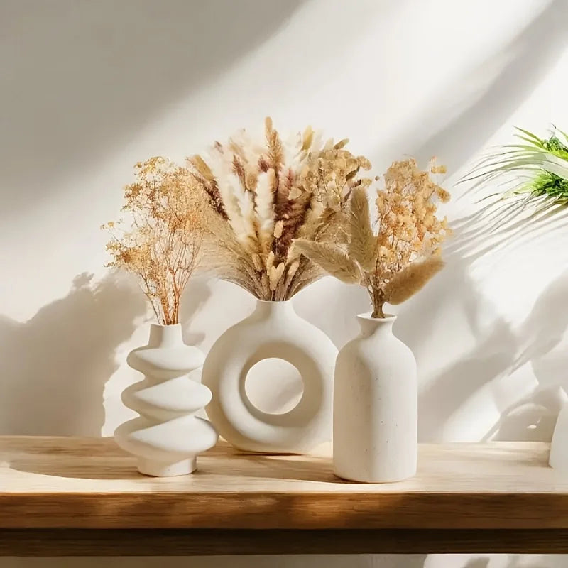 White bohemian ceramic vase trio displayed with dried pampas grass stems