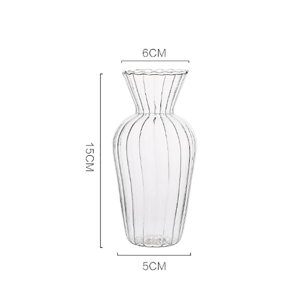 Small Nordic transparent glass vase with single flower stem on work desk