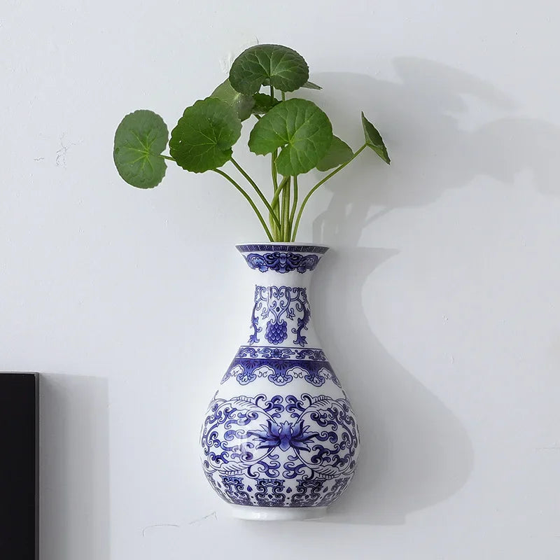 Set of three blue white ceramic vases in varying heights on shelf