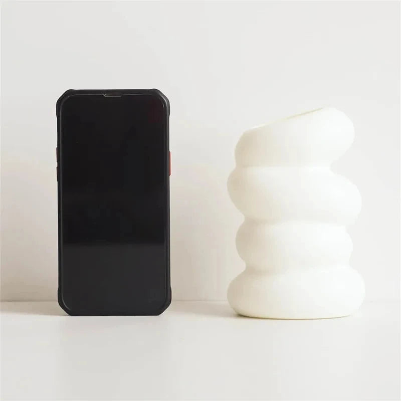 Small white spiral plastic vase with dried botanical stems for kitchen accent