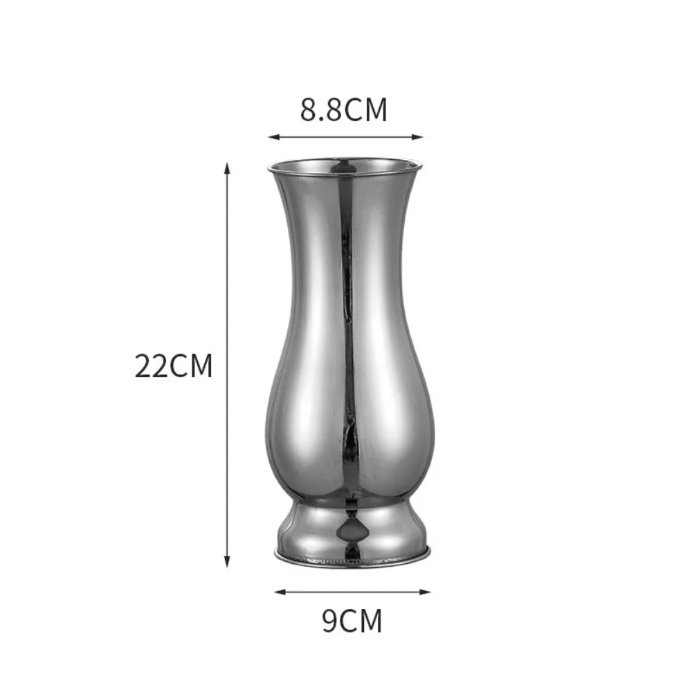 Gold vase reflecting light on contemporary glam-styled dining table surface