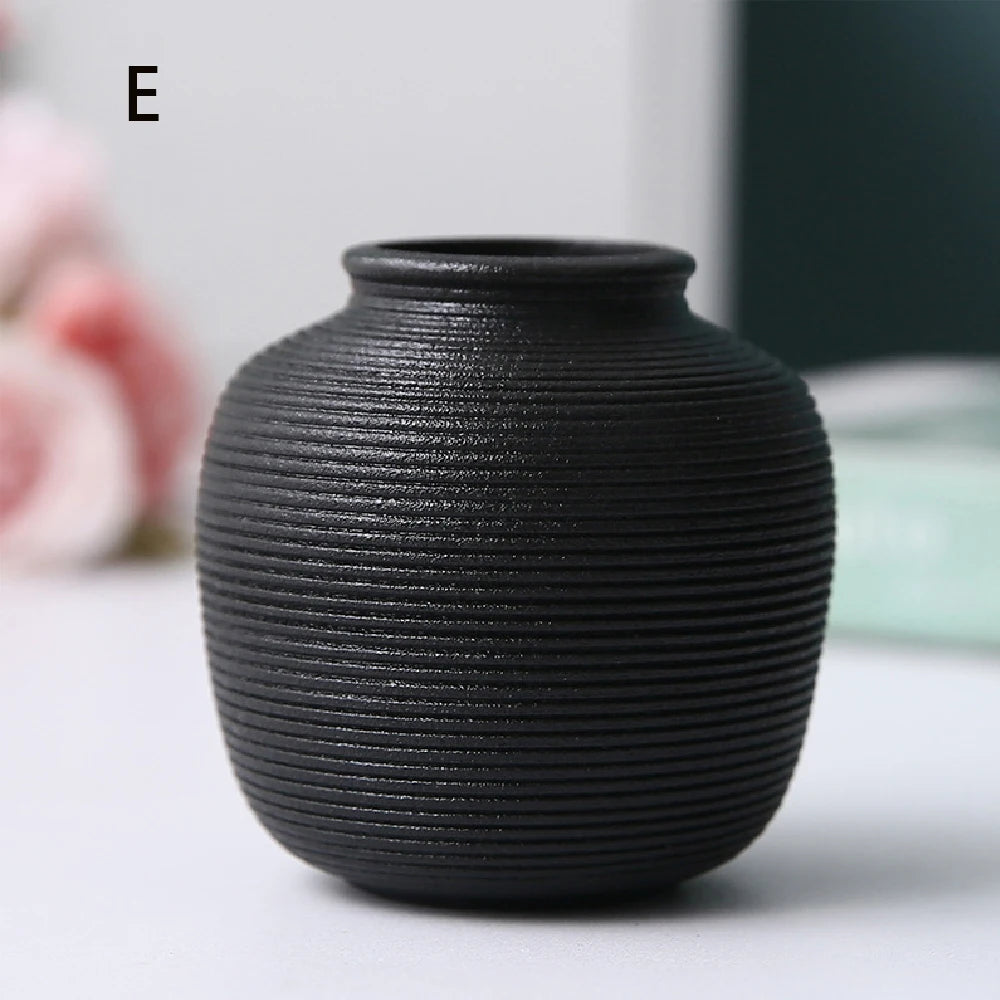 Black angled ceramic vase D with dried eucalyptus sprig in Scandi styled interior
