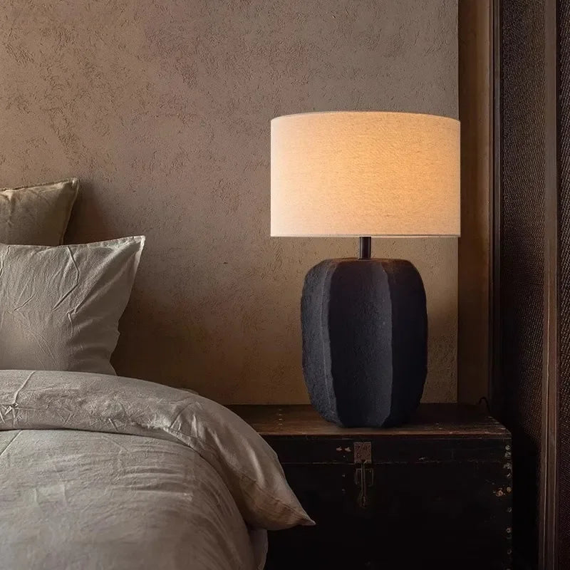 Side view of black clay pottery lamp with linen fabric shade