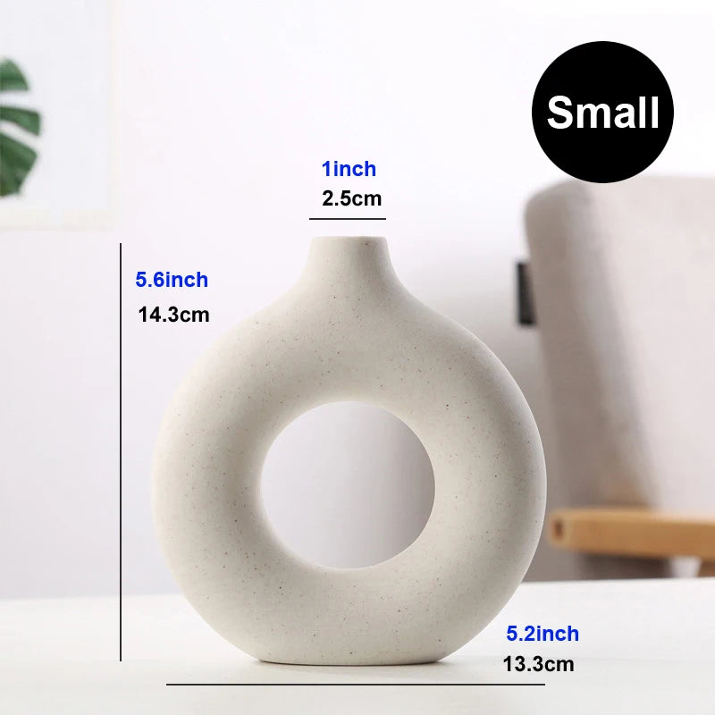 Nordic hollow donut ceramic vase on marble surface with a clean white background