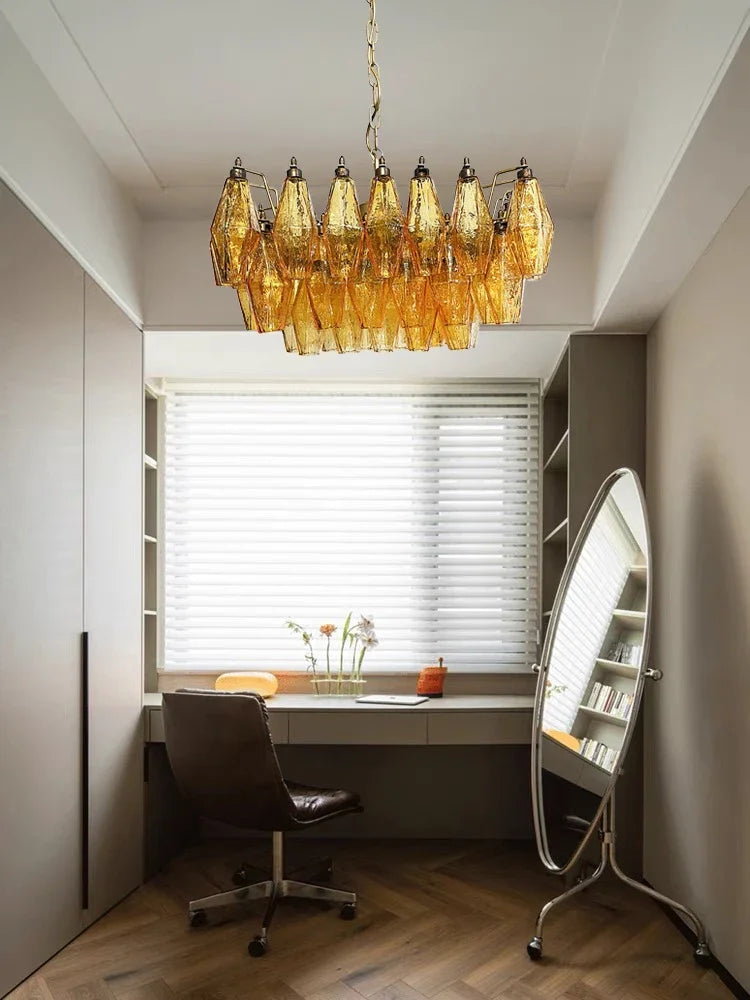 Amber glass shades clustered at varied heights on slim steel chandelier arms