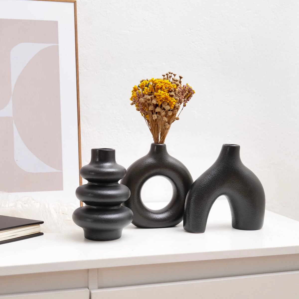 White and black bohemian vase pair styled together on a minimalist mantelpiece