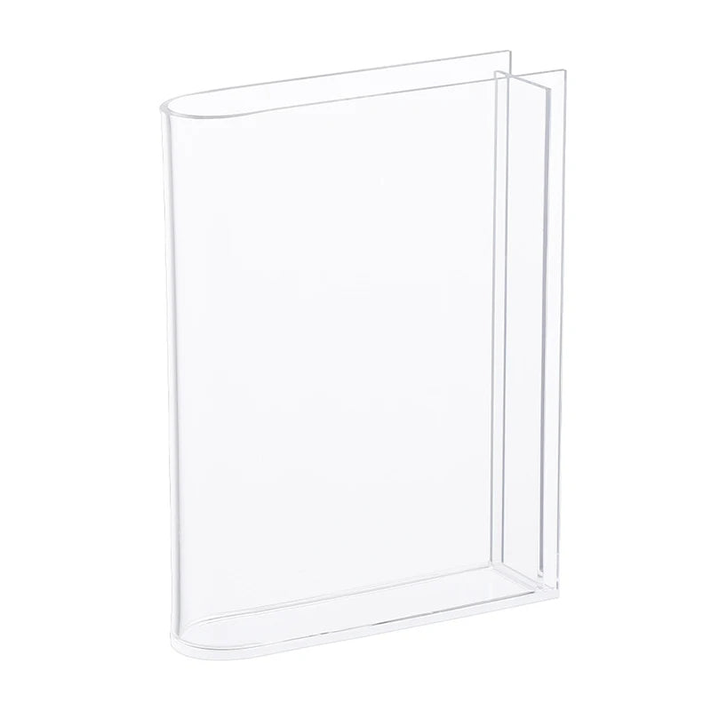 Overhead view of clear acrylic book vase showing open-book silhouette and flower display