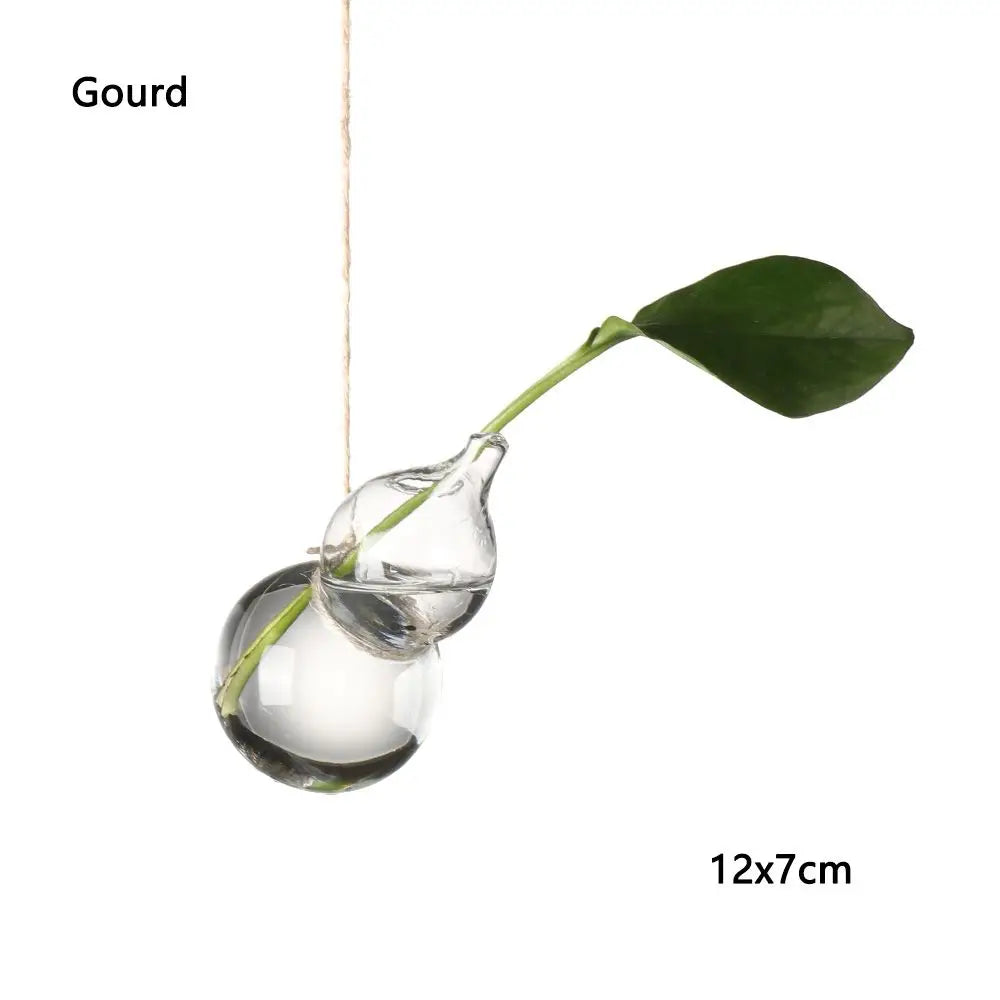 Water droplet glass vase trio hanging at varying heights on copper wall hooks