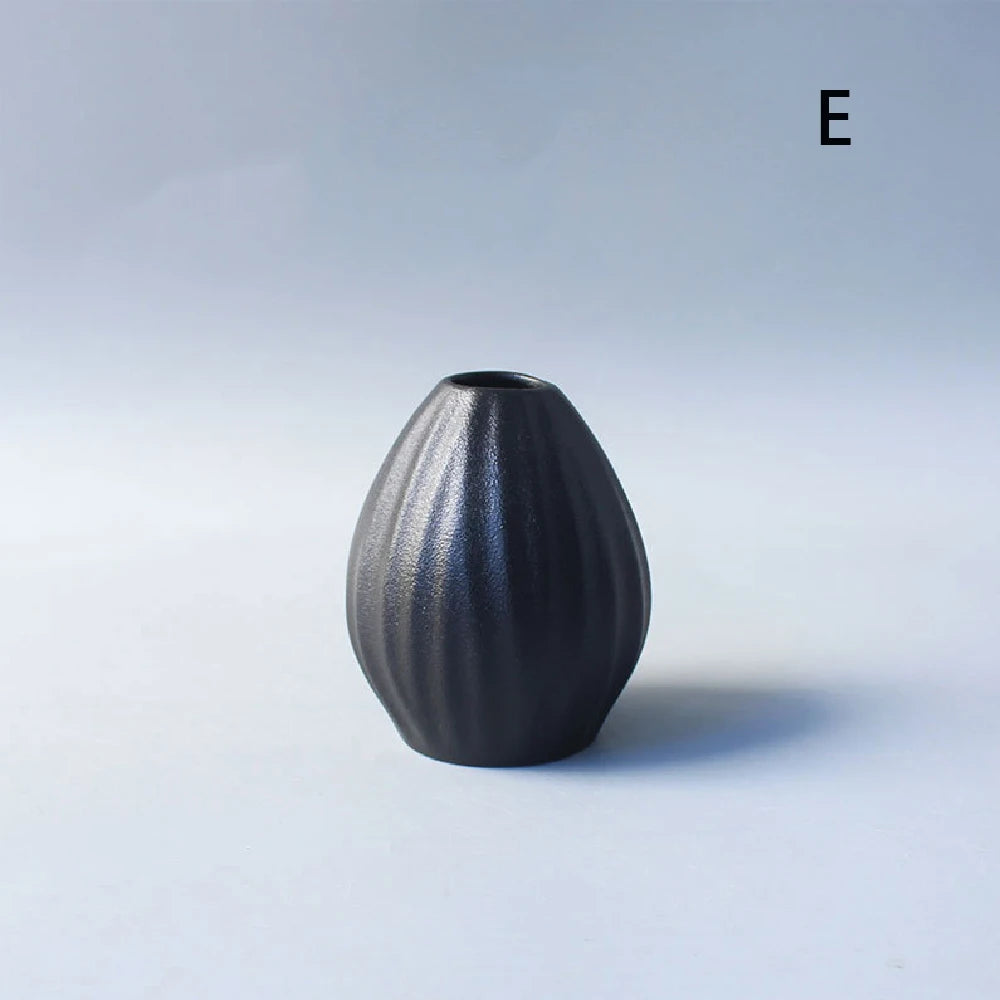Japanese black ceramic bud vase with single dried flower in zen interior