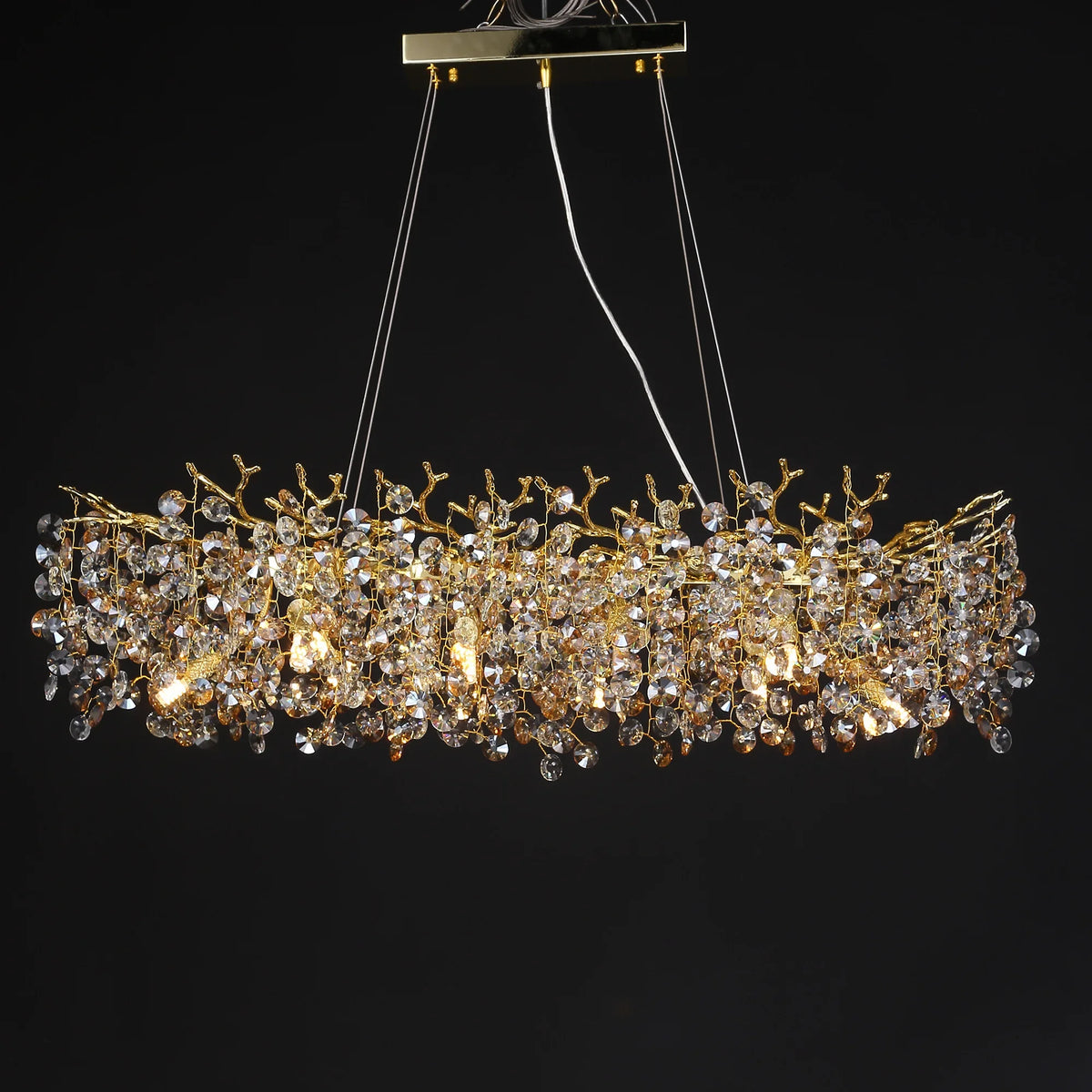 Crystal branch detail on a gold chandelier frame with warm 3000K light sources