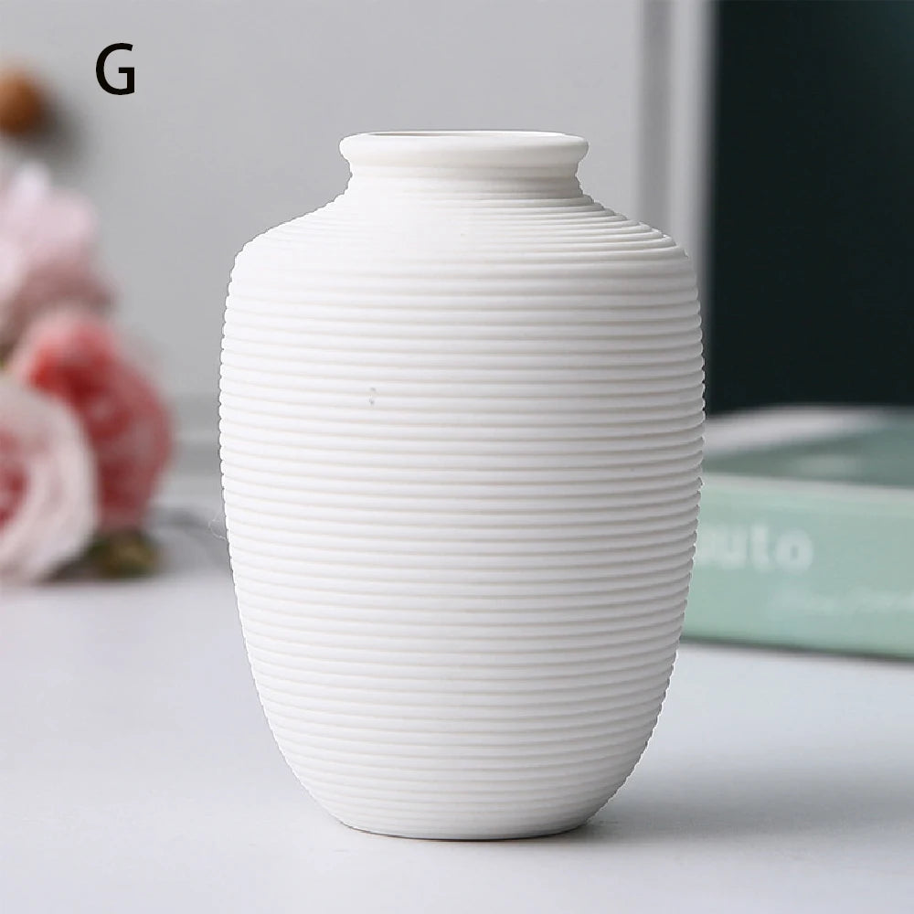 Collection of small black ceramic vases in three forms styled as botanical shelf display