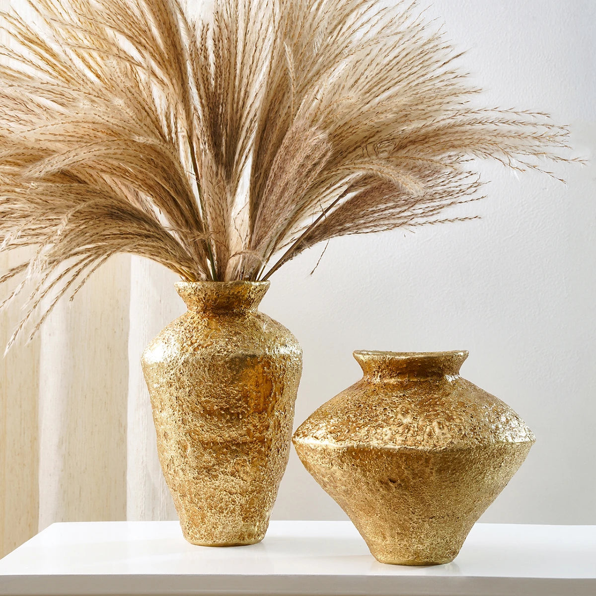 Tall narrow antique gold earthenware jar vase on a traditional rustic sideboard