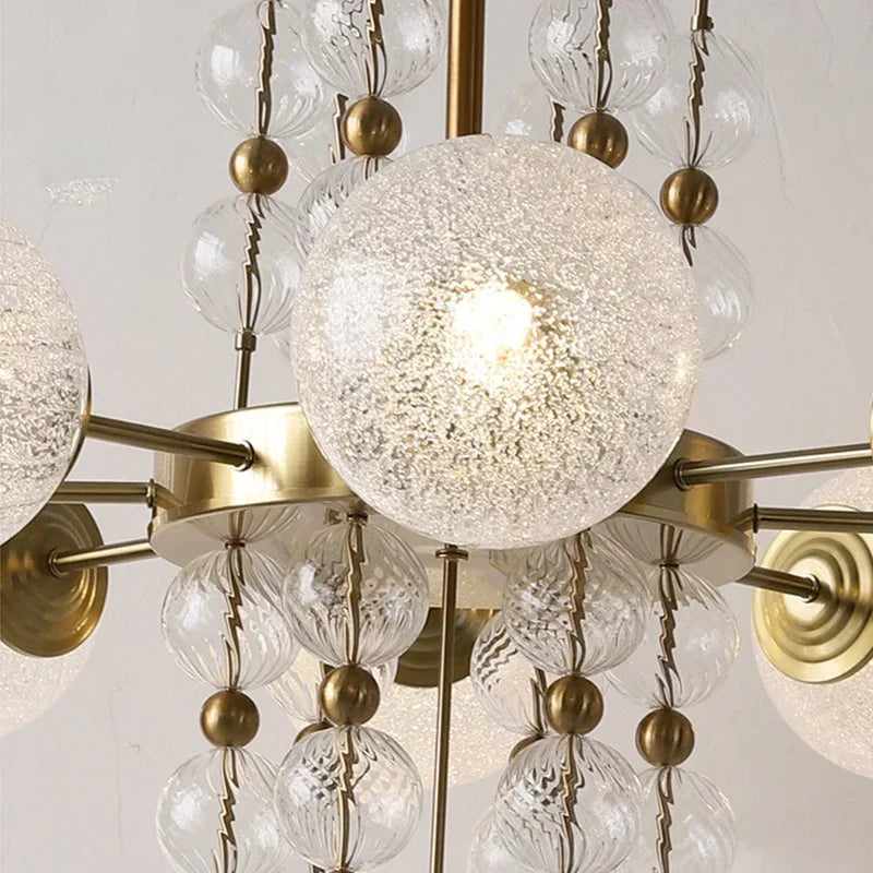 Glass bubble chandelier shown lit in warm white E27 LED light