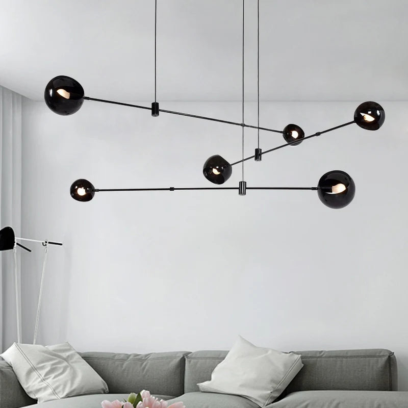 Black globe linear chandelier with stained glass shades on an iron bar