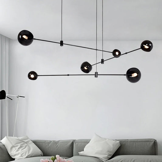 Black globe linear chandelier with stained glass shades on an iron bar
