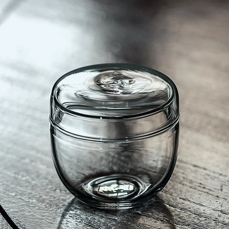 Glass bottle moss terrarium with small plant inside on home desk