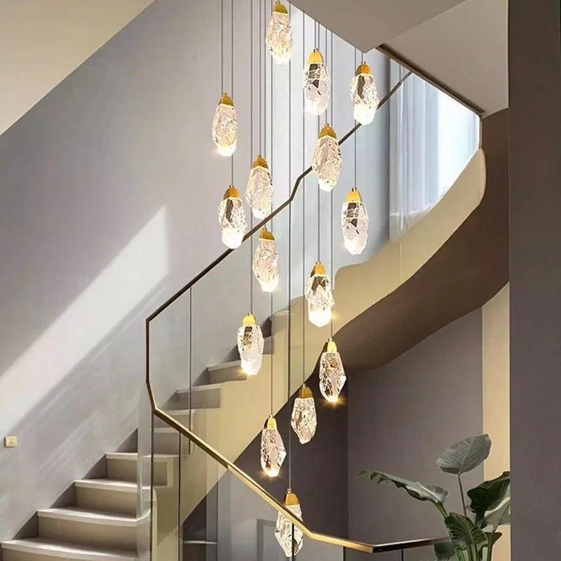 Crystal stair chandelier lit in warm 3000K light down a void