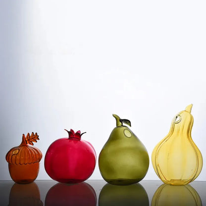 Hand-blown glass pomegranate shaped bud vase on wooden desk surface