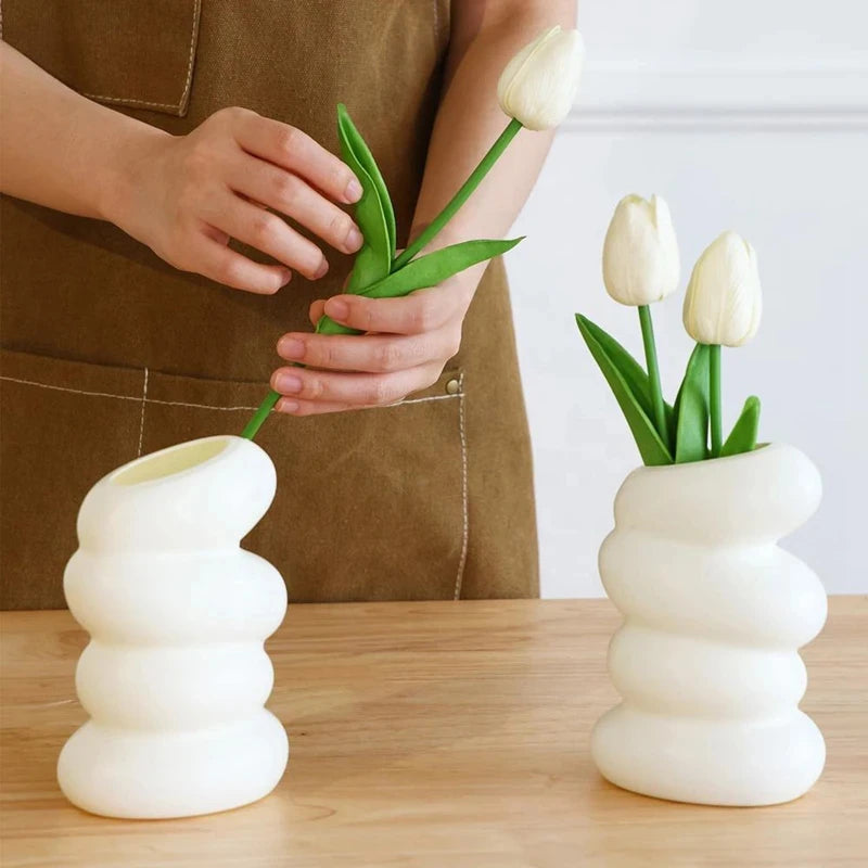 White Nordic spiral vase with dried pampas grass on minimalist home shelf