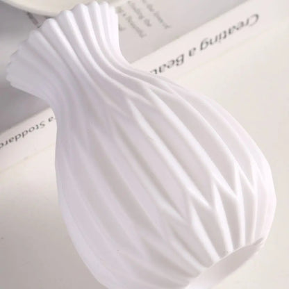 White plastic vase styled with white flowers as a party or event table prop