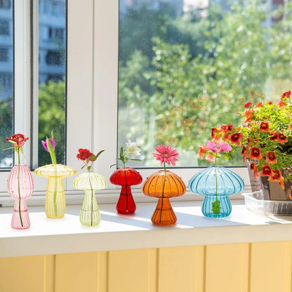 Side view of transparent mushroom bud vase with small fresh flower stem