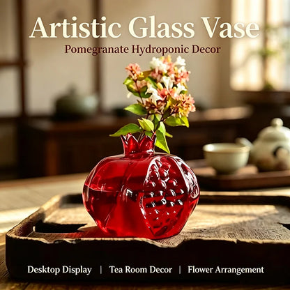 Large pomegranate glass vase holding fresh flower stems on dining table centrepiece