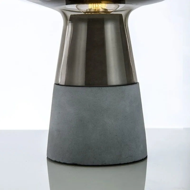 Amber glass desk lamp illuminated in modern minimalist bedroom