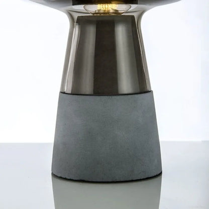 Amber glass desk lamp illuminated in modern minimalist bedroom