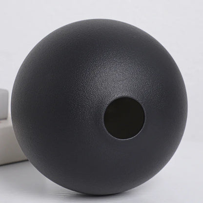 Large black ball ceramic vase as floor accent in modern living room