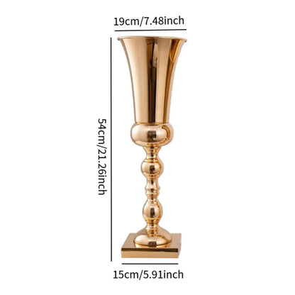 Gold metal flower stand vase placed on round banquet table with white linens