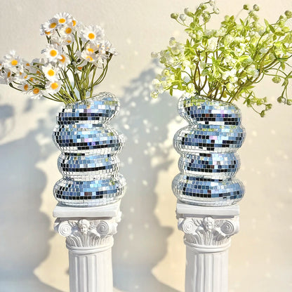 Silver disco ball vase on a dining table centrepiece with candles and flowers