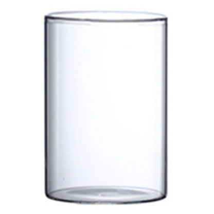 Two glass cylinder vases with floating tea light candles as elegant table centerpiece